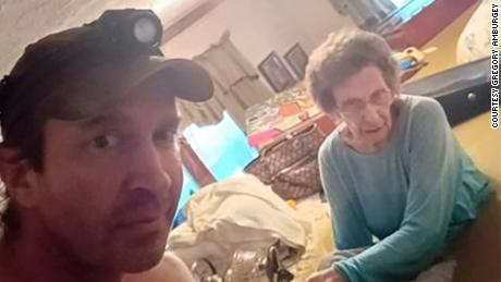 Gregory Amburgey with his 98-year-old grandmother, Mae Amburgey, in a house submerged in water.