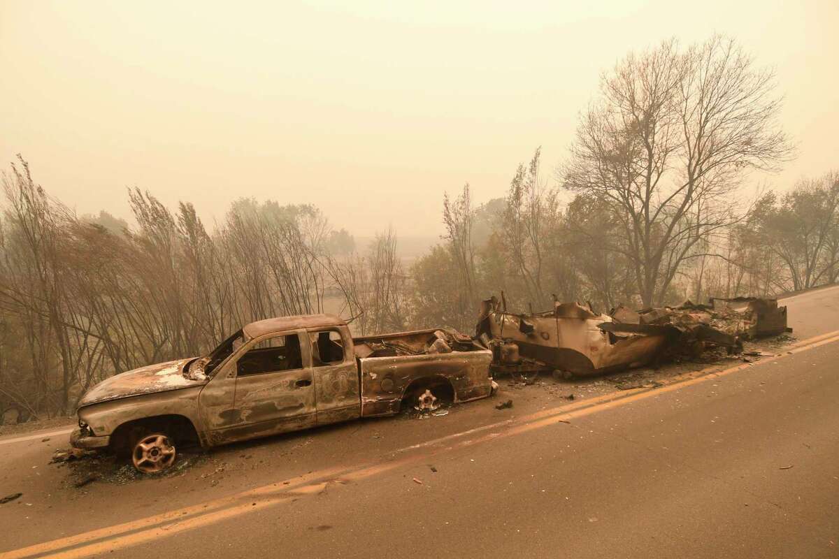 A pickup truck and trailer that burned overnight in the middle of State Route 96 are destroyed by the McKinney Fire in the community of Klamath River, Calif., Saturday, July 30, 2022. (Scott Stoddard/Grants Pass Daily Courier through AP)