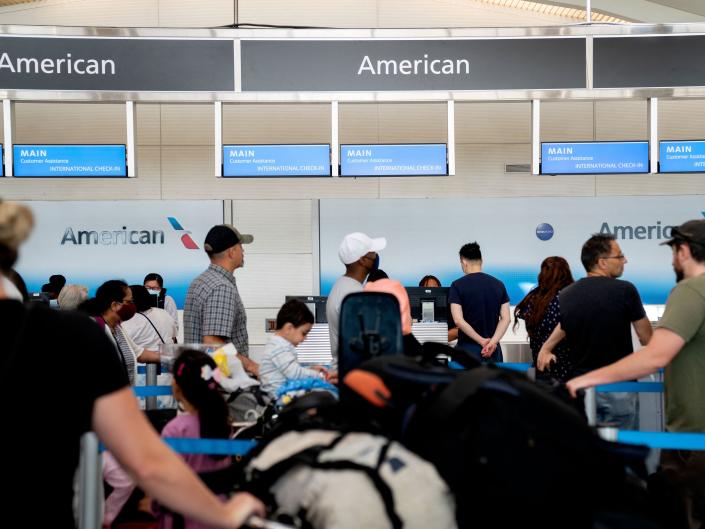 Travelers line up at the American Airlines counter at Ronald Reagan Washington National Airport in Arlington, Virginia on July 2, 2022