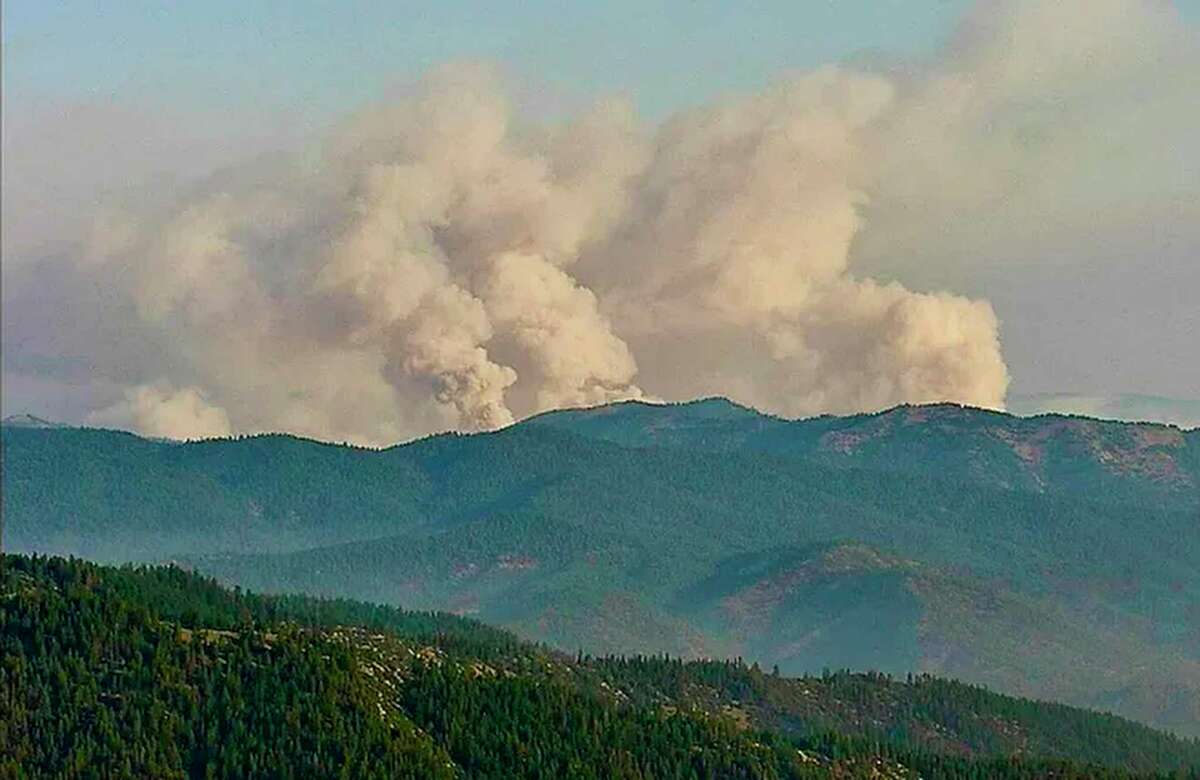 Three plumes of smoke from the McKinney Fire are seen early Saturday, July 30, 2022, from a California Department of Forestry and Fire Protection, Cal Fire, outdoor camera called Antelope Mt./Yreka.  (California Department of Forestry and Fire Protection/Cal Fire via AP)