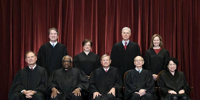 Members of the Supreme Court pose for a group photo in Washington on April 23, 2021.