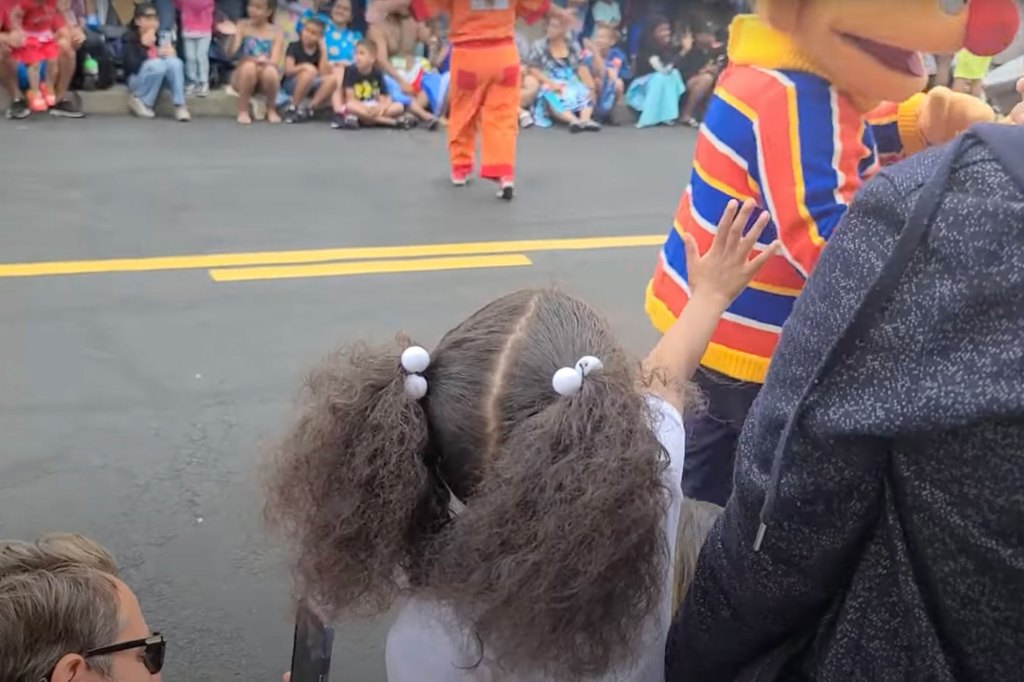 A young black girl reaches out for a handshake from Ernie in Sesame Park but he walks right past her.