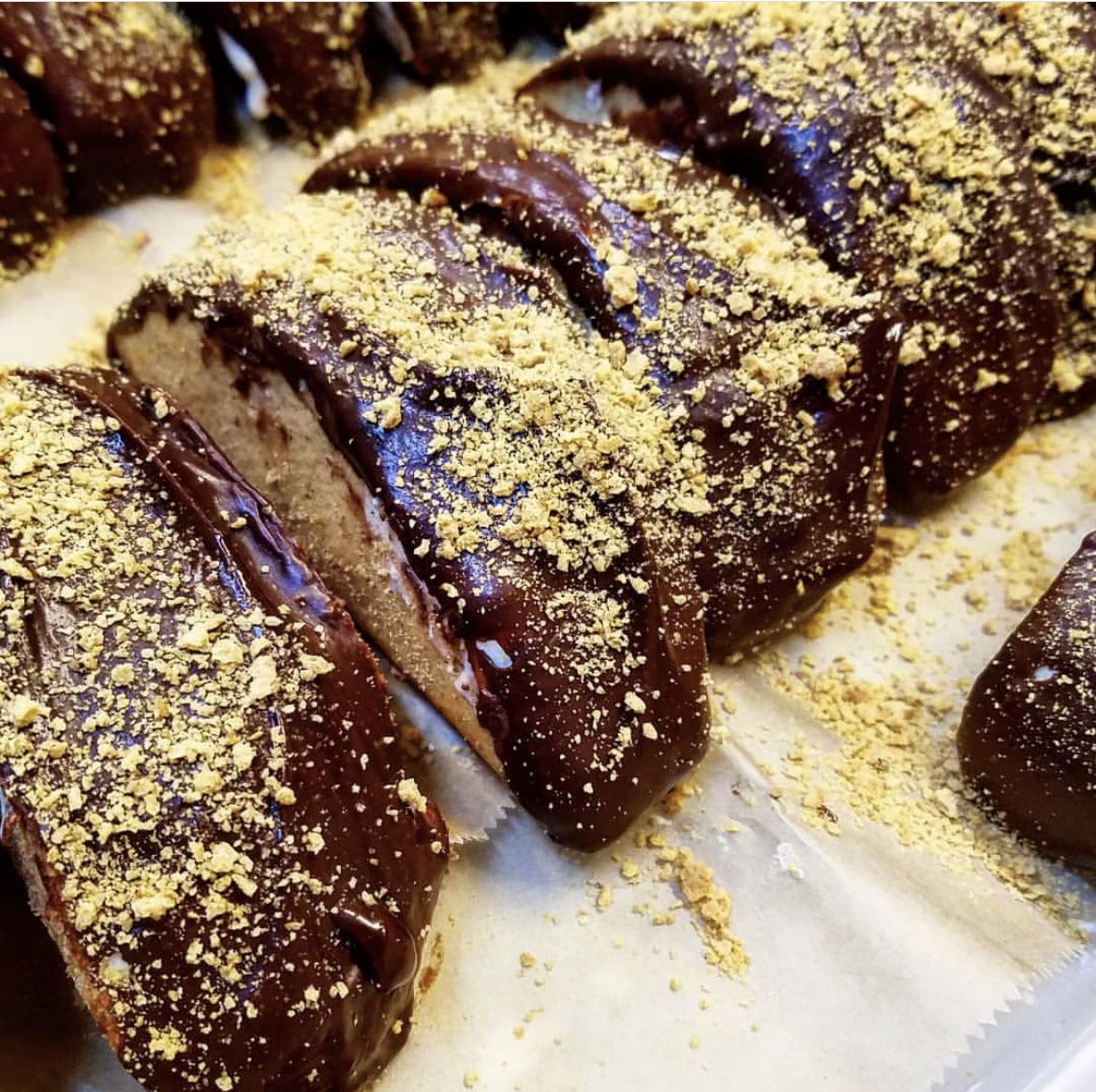 Close up of a row of restaurant made Choco Tacos, with shiny chocolate and a crumbly cookie filling.