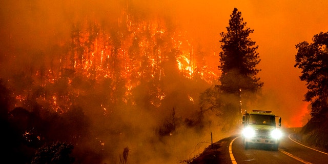 A fire truck drives along California Highway 96 as the McKinney Fire burns in Klamath National Forest, California on July 30, 2022.